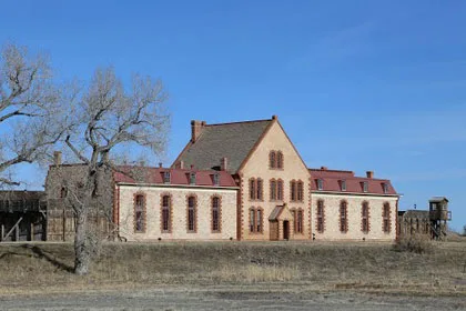 Historic stone building with red roofs on open grassland in Albany County, WY