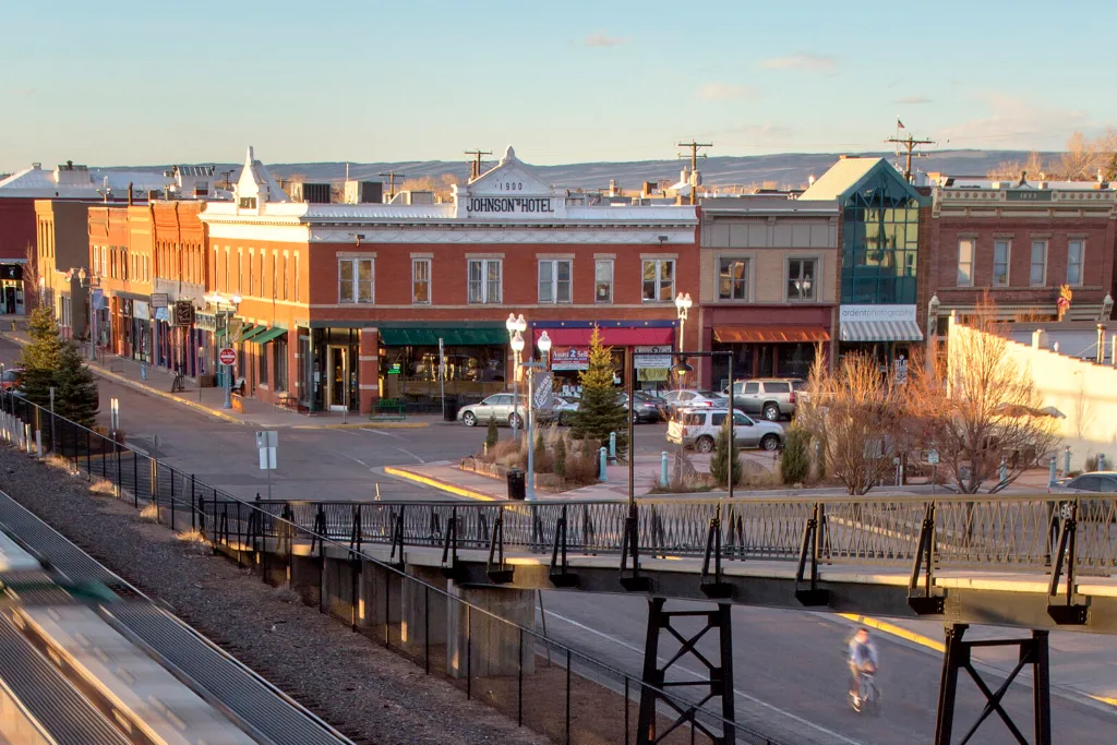 Downtown buildings beside a rail yard and pedestrian bridge in Wyoming