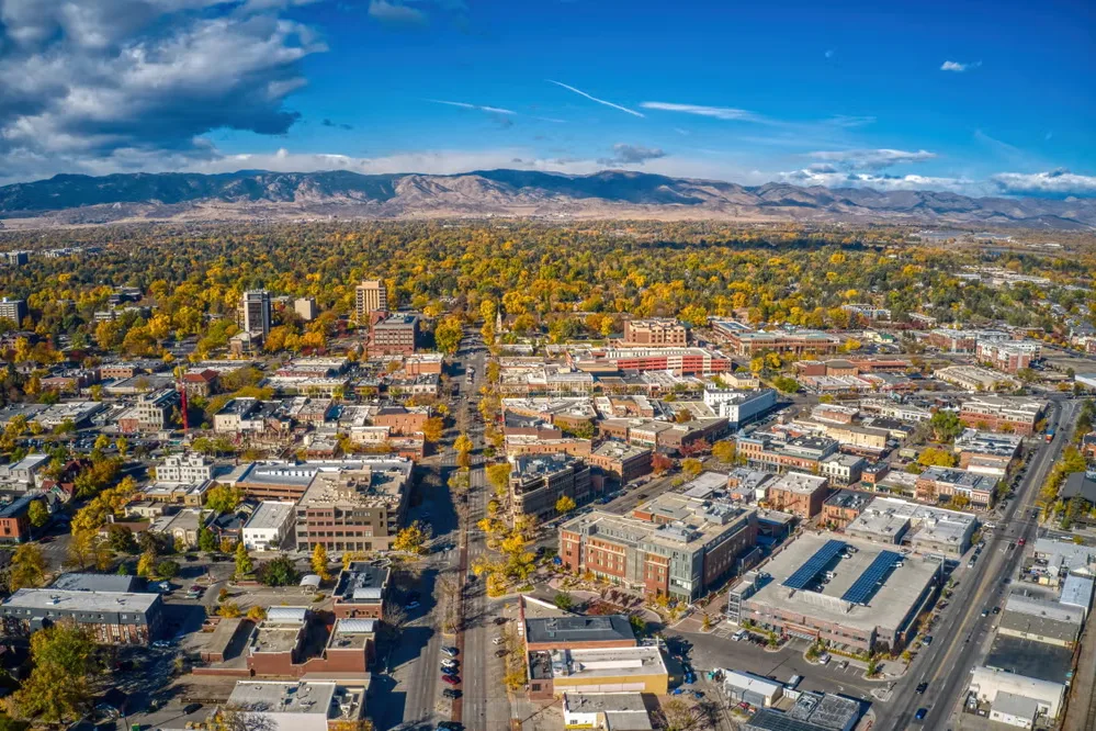 Aerial view of downtown Windsor, CO with autumn trees and the Front Range